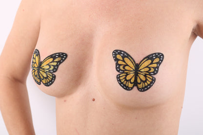 Model Image - Neon Orange Bufferfly Glitter Pasties applied to bust of female model
